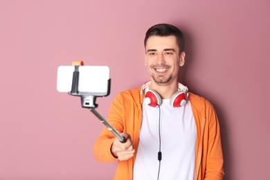 Photo of Handsome man taking selfie against color background