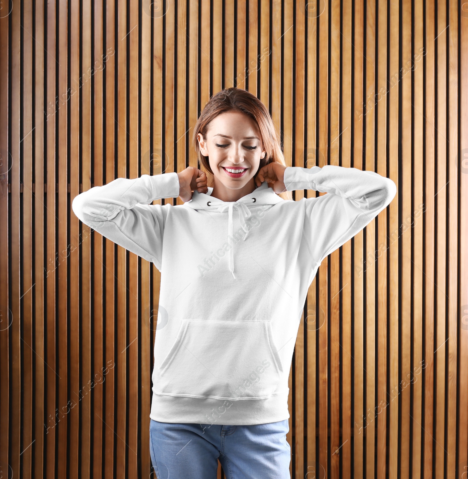 Photo of Portrait of woman in hoodie sweater on wooden background. Space for design