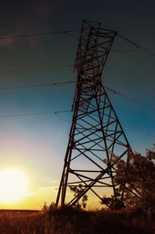 Photo of High voltage tower against beautiful blue sky, low angle view