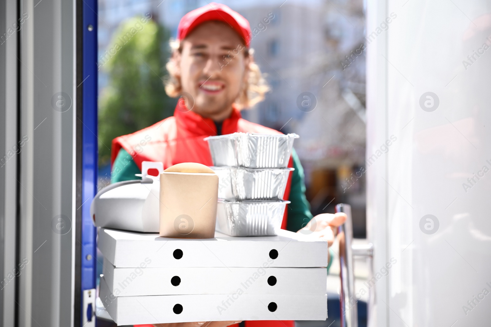 Photo of Male courier with order at open door. Food delivery service
