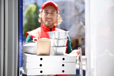 Male courier with order at open door. Food delivery service