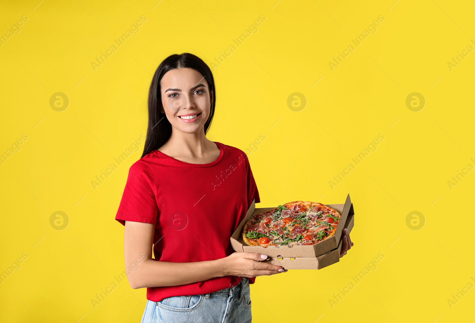 Photo of Beautiful woman with tasty pizza on yellow background