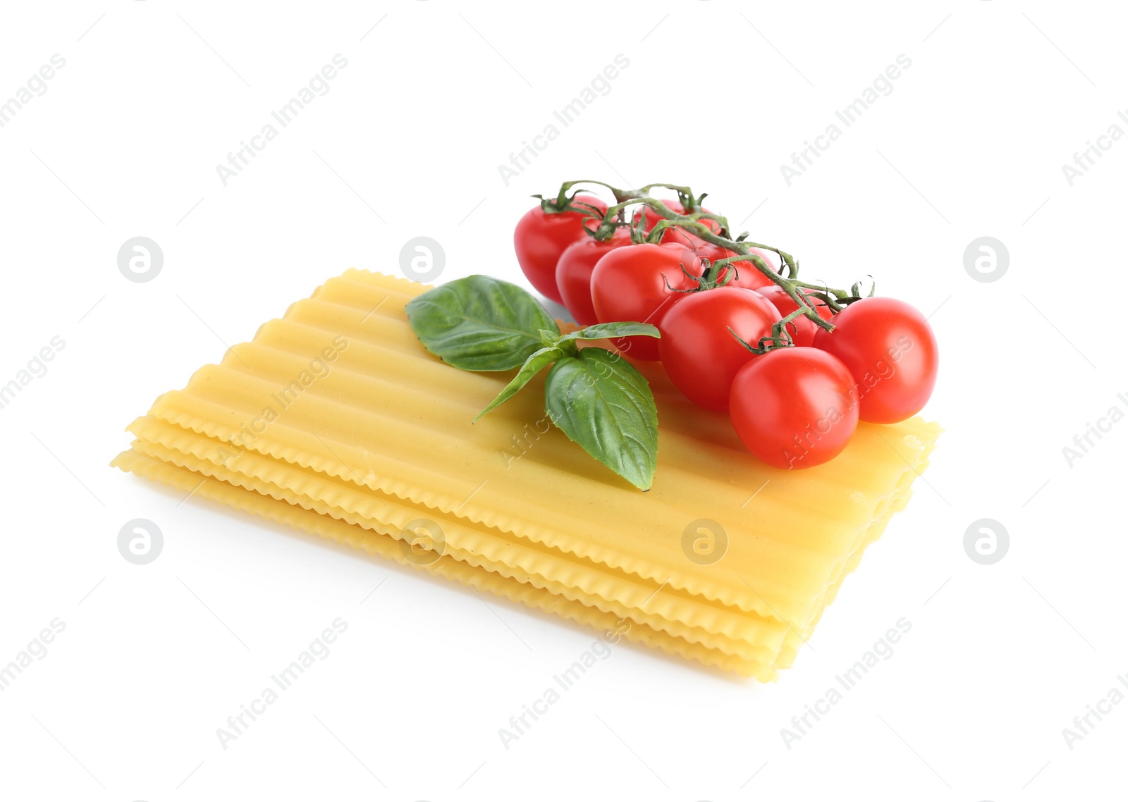 Photo of Uncooked lasagna sheets, cherry tomatoes and basil isolated on white