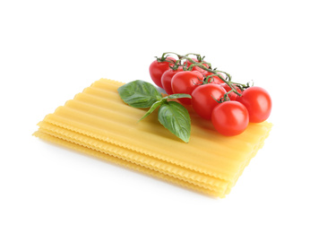 Uncooked lasagna sheets, cherry tomatoes and basil isolated on white