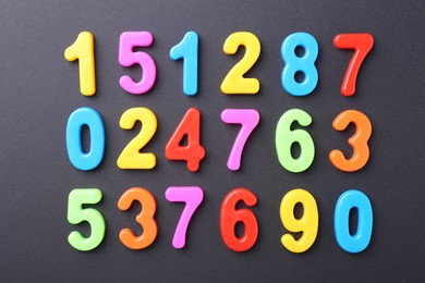 Photo of Colorful numbers on dark gray background, flat lay