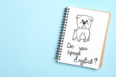 Notebook with question Do You Speak English on light blue background, top view. Space for text