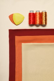 Photo of Flat lay composition with sewing threads on beige background