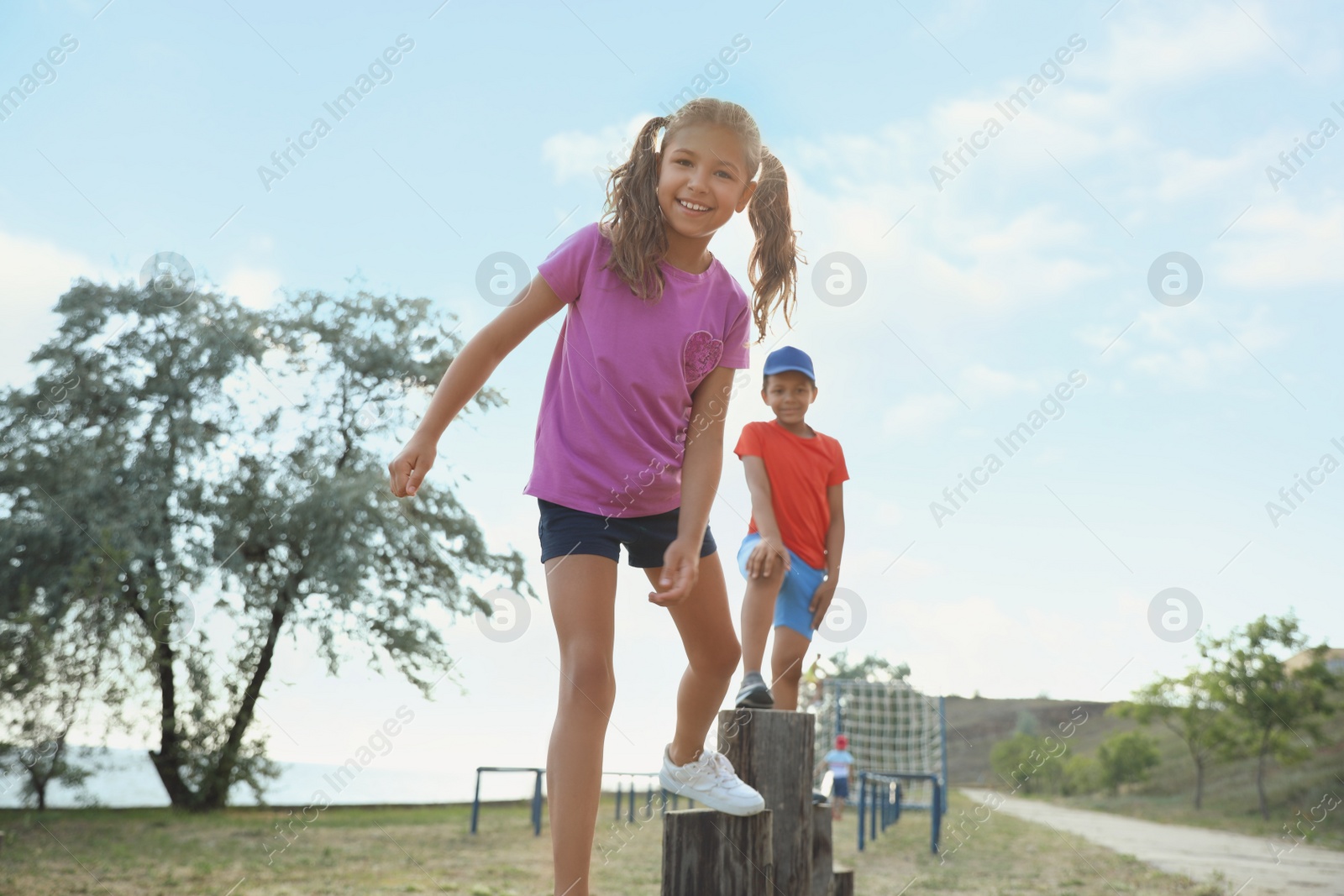 Photo of Cute children at outdoor playground on sunny day. Summer camp