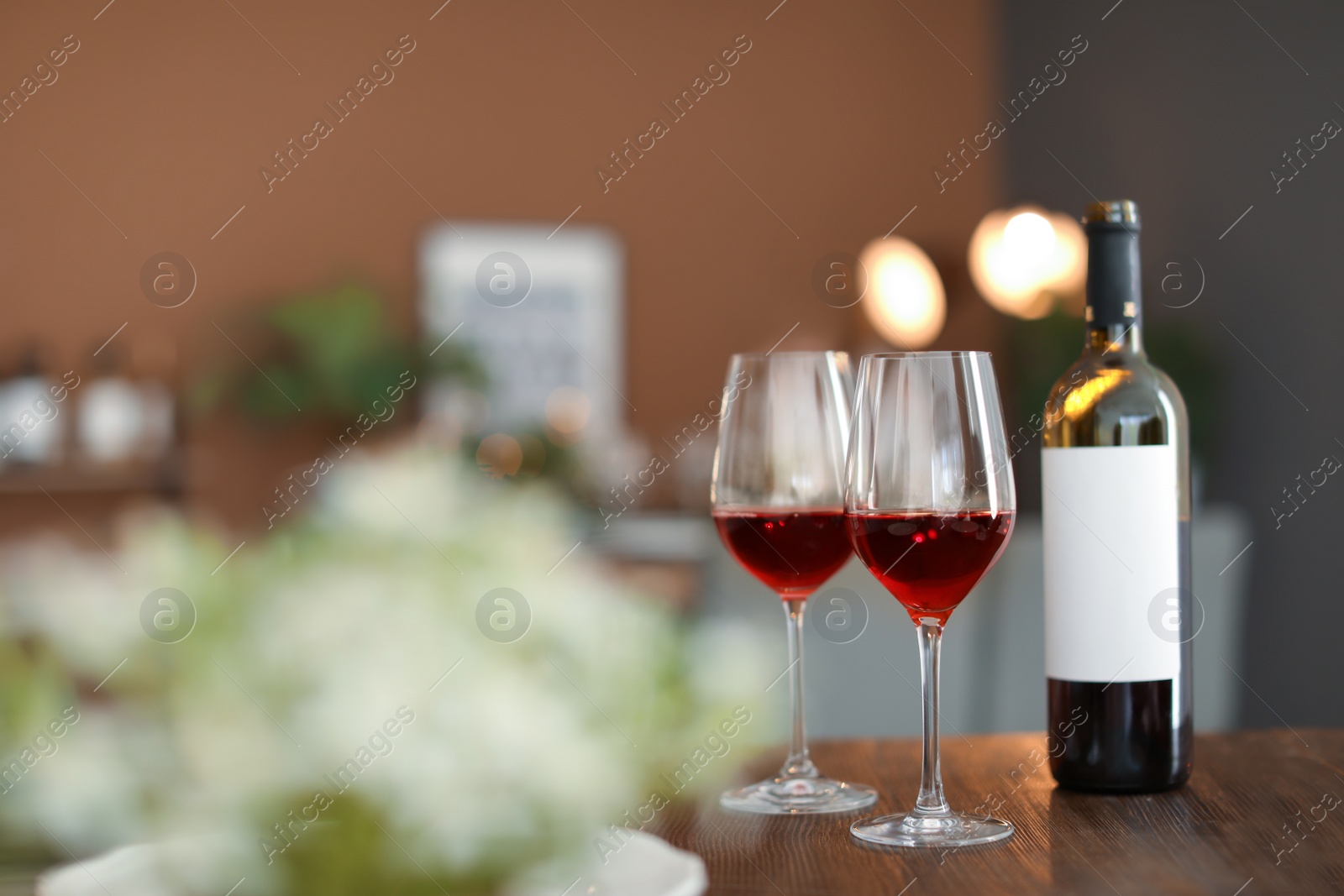 Photo of Glasses and bottle with tasty wine on table in restaurant