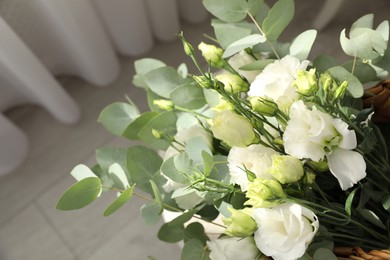 Photo of Beautiful bouquet in wicker basket indoors, closeup