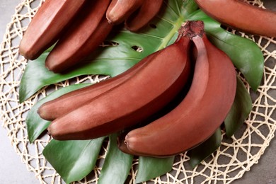 Tasty red baby bananas on grey table, flat lay