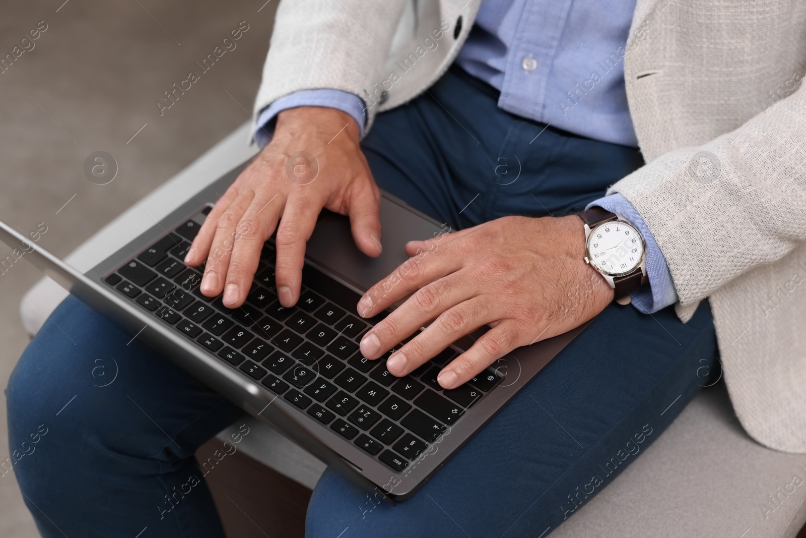 Photo of Man using laptop on light background, closeup