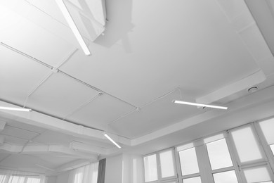 White ceiling with modern lighting in office