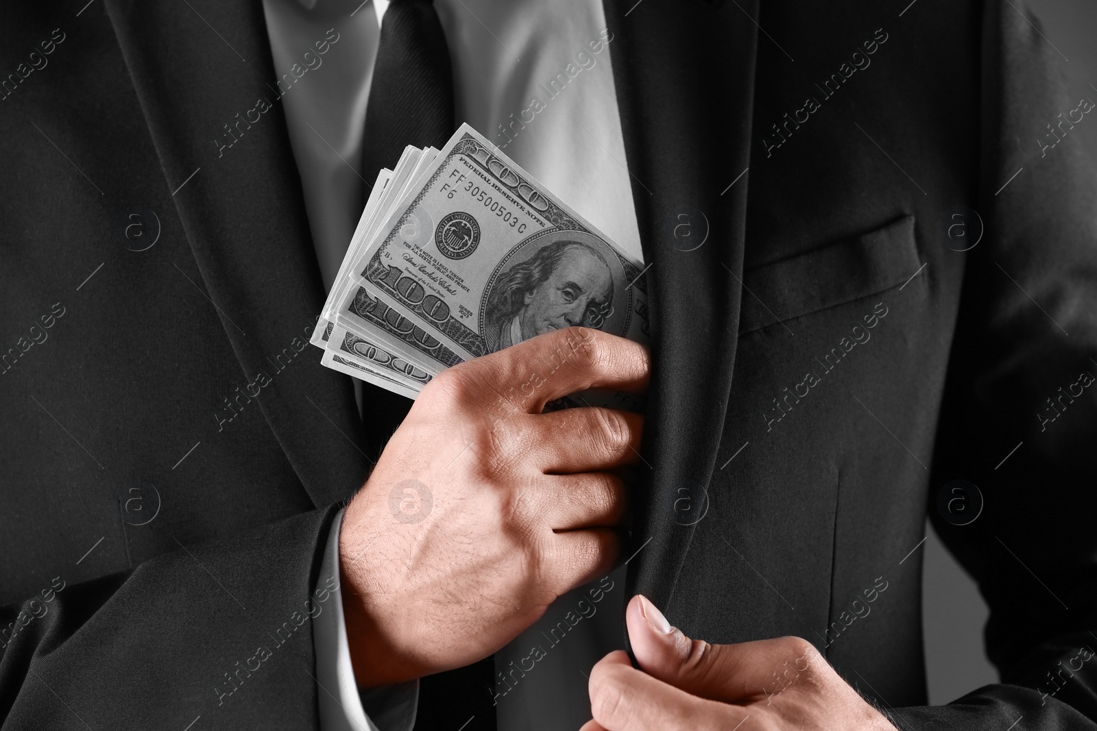 Photo of Man with bribe money on dark background, closeup