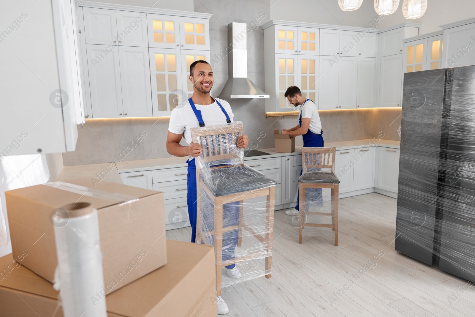 Photo of Male movers with chairs in new house