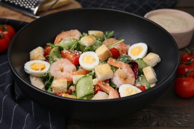 Delicious Caesar salad with shrimps on table, closeup