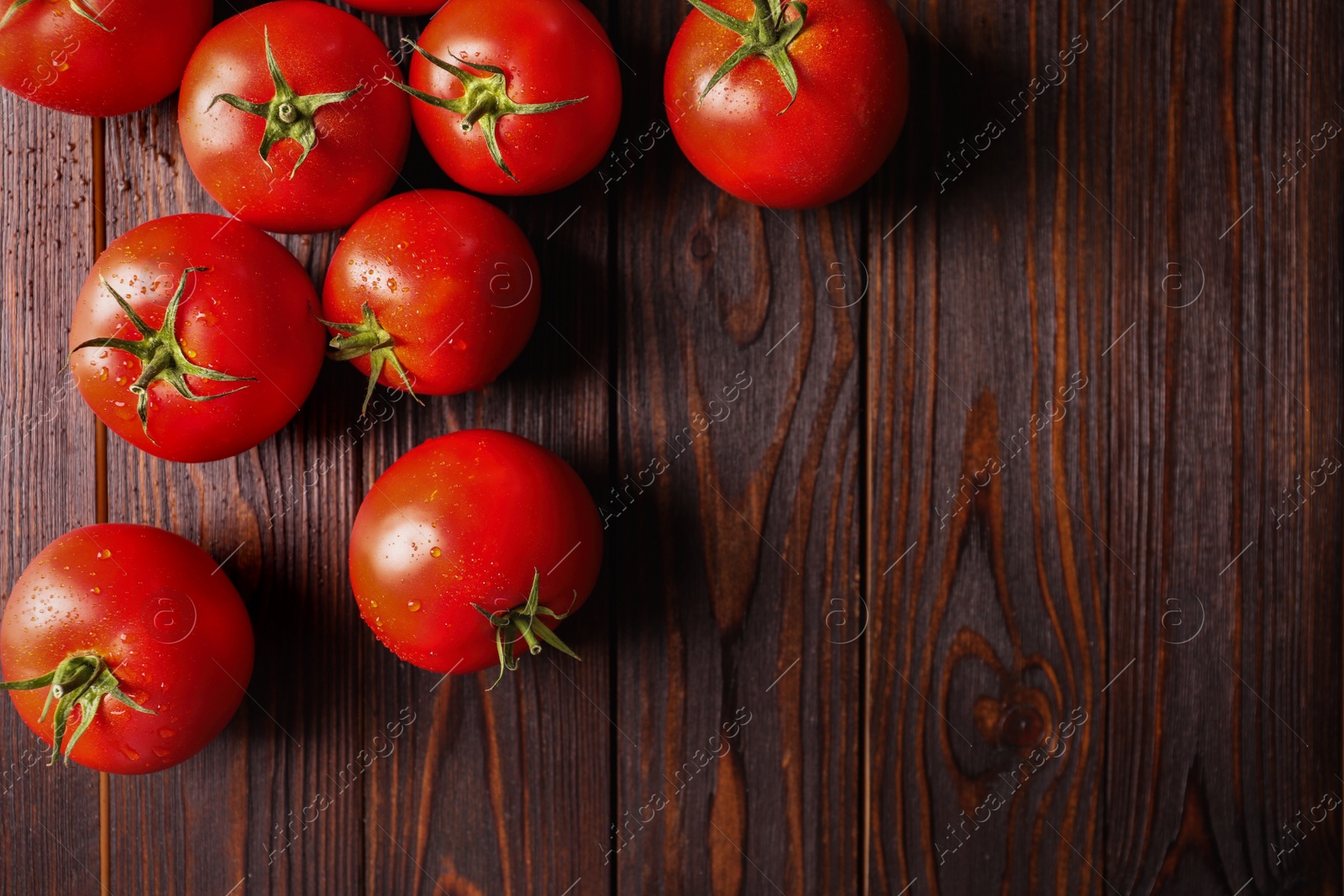 Photo of Fresh ripe tomatoes on wooden table, flat lay. Space for text