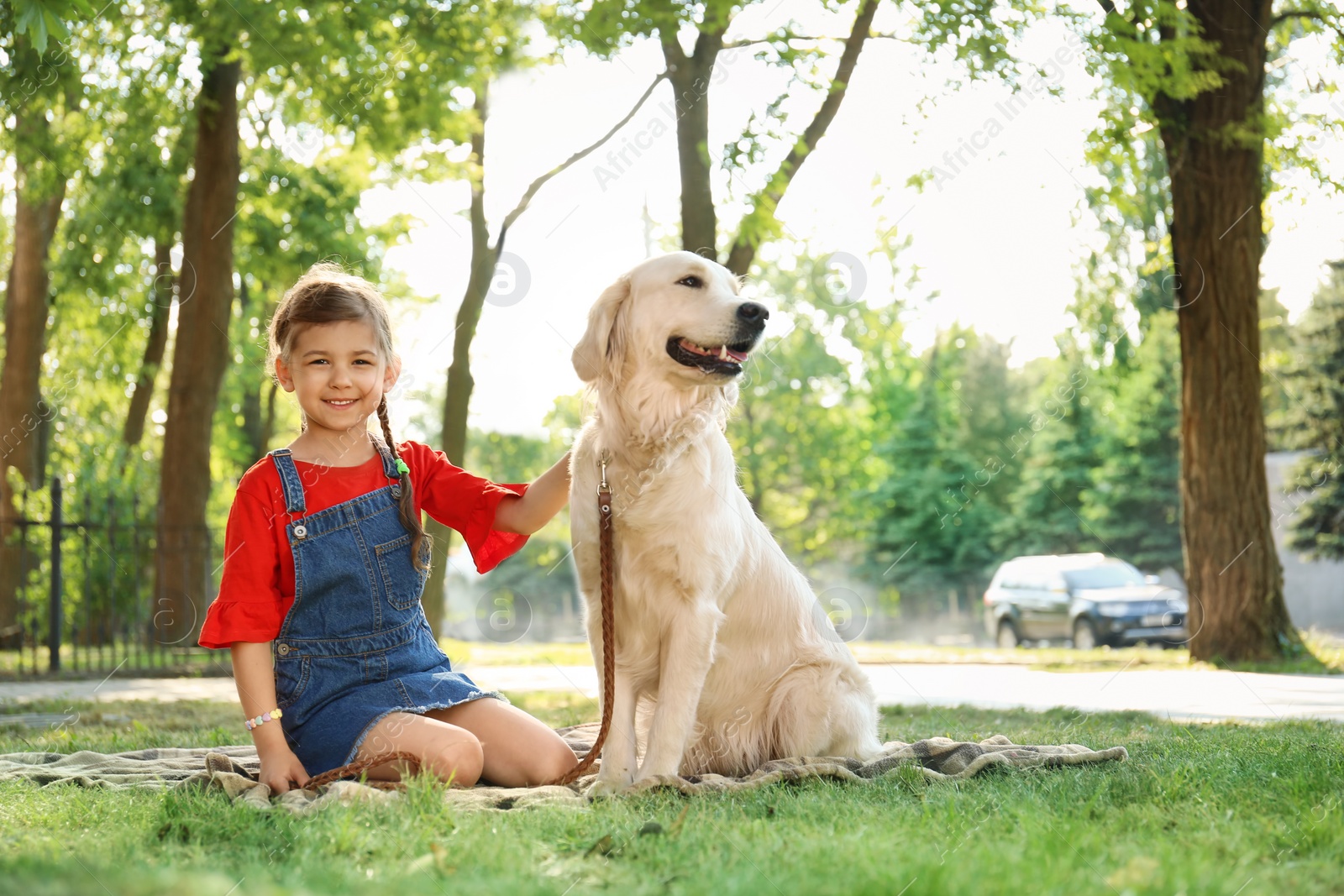 Photo of Cute little child with his pet in green park