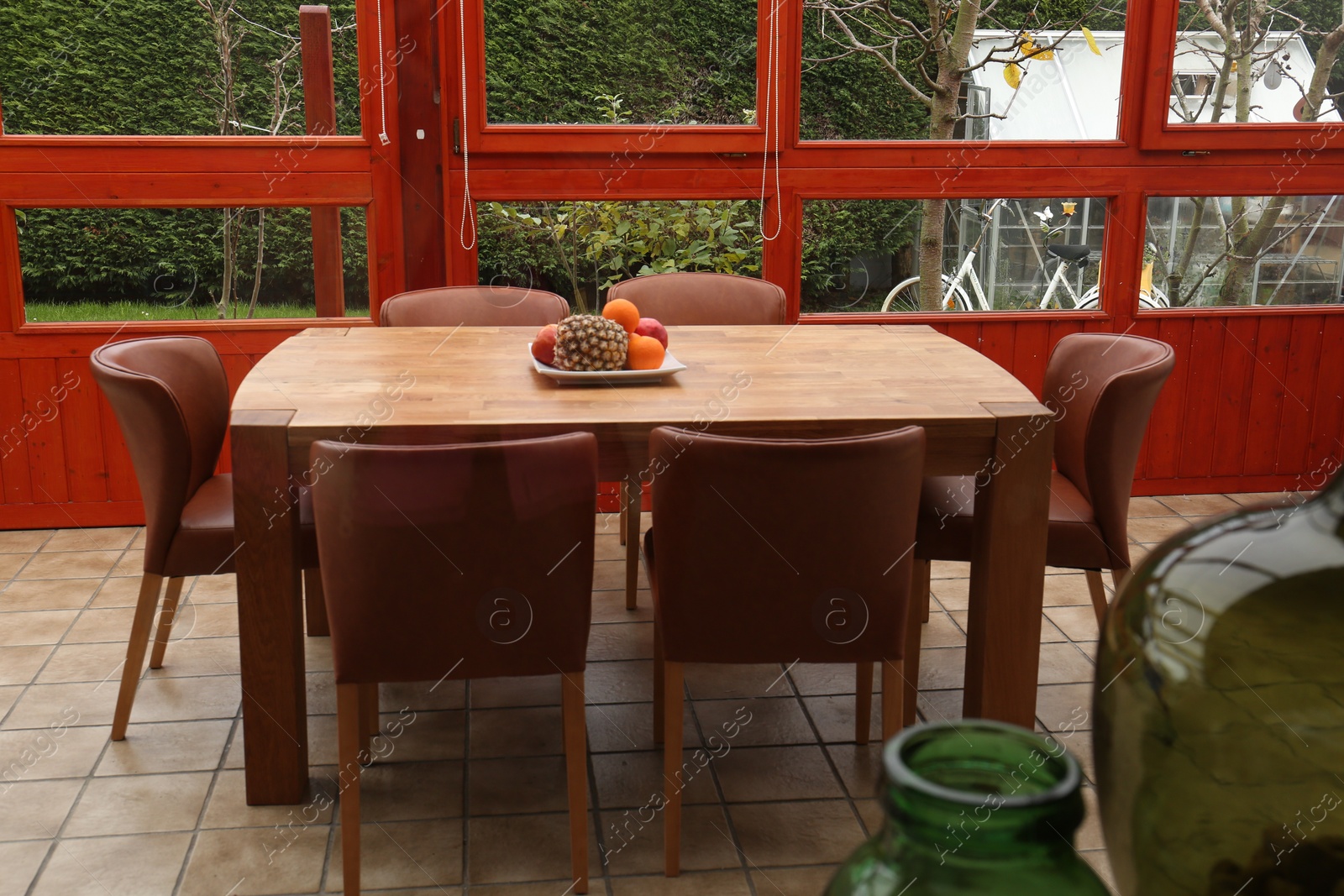 Photo of Wooden table with fruits and stylish chairs on terrace