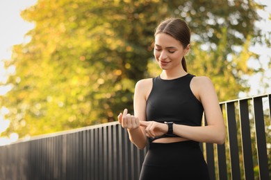 Photo of Attractive happy woman checking pulse after training in park. Space for text