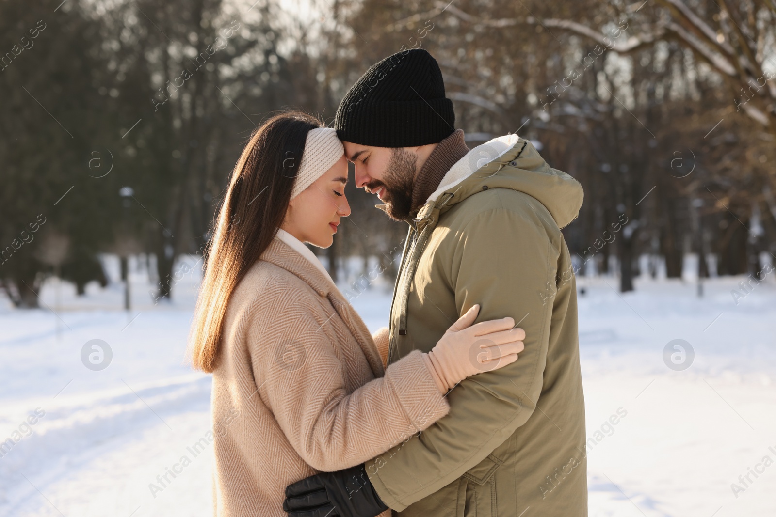 Photo of Beautiful happy couple in snowy park on winter day