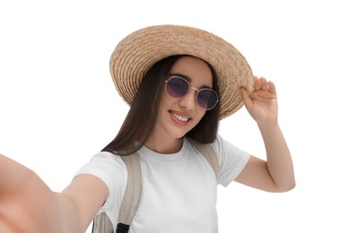 Smiling young woman in sunglasses and straw hat taking selfie on white background