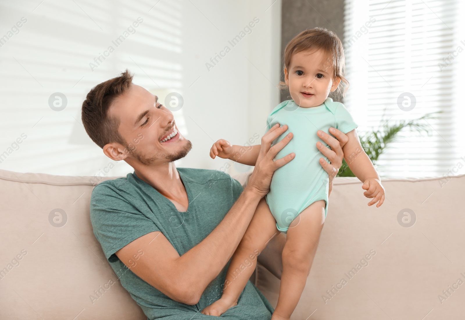 Photo of Father with adorable little baby at home. Happy family