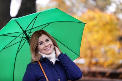 Woman with umbrella in autumn park on rainy day