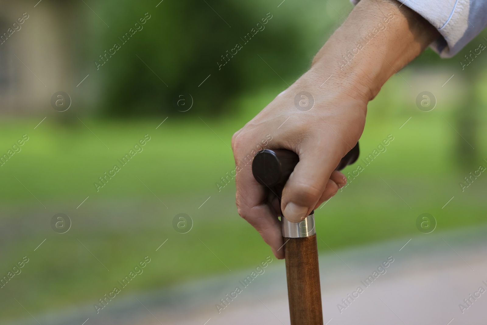 Photo of Senior man with walking cane outdoors, closeup