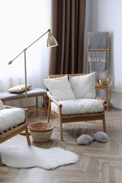 Beautiful living room interior with wooden armchairs on white fluffy rug