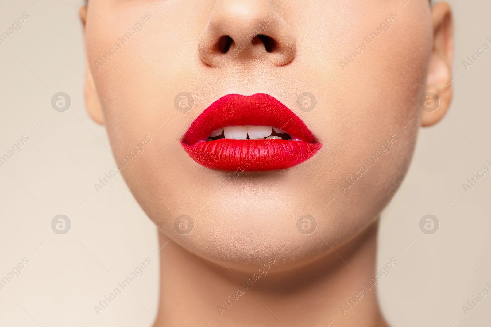 Photo of Beautiful young woman with red lips on color background, closeup