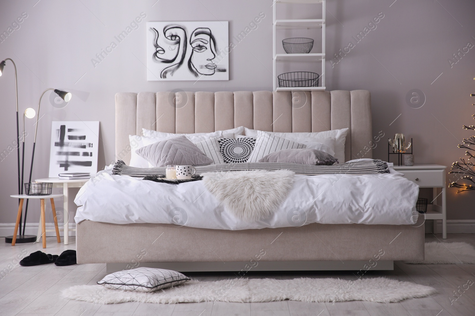 Photo of Cozy bedroom interior with cushions and beautiful pictures