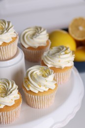 Delicious lemon cupcakes with white cream on table, closeup