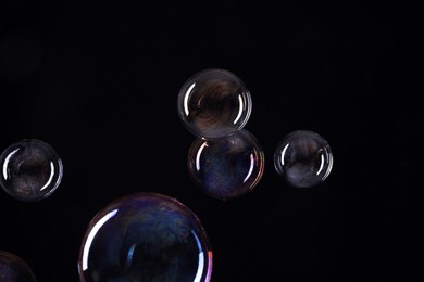 Photo of Beautiful soap bubbles on black background. Space for text