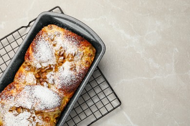 Photo of Delicious yeast dough cake in baking pan on marble table, top view. Space for text