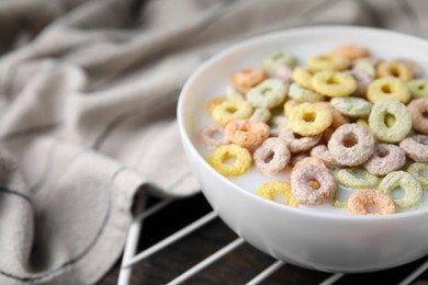 Photo of Cereal rings and milk in bowl on table, closeup. Space for text