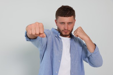 Photo of Young man ready to fight on white background