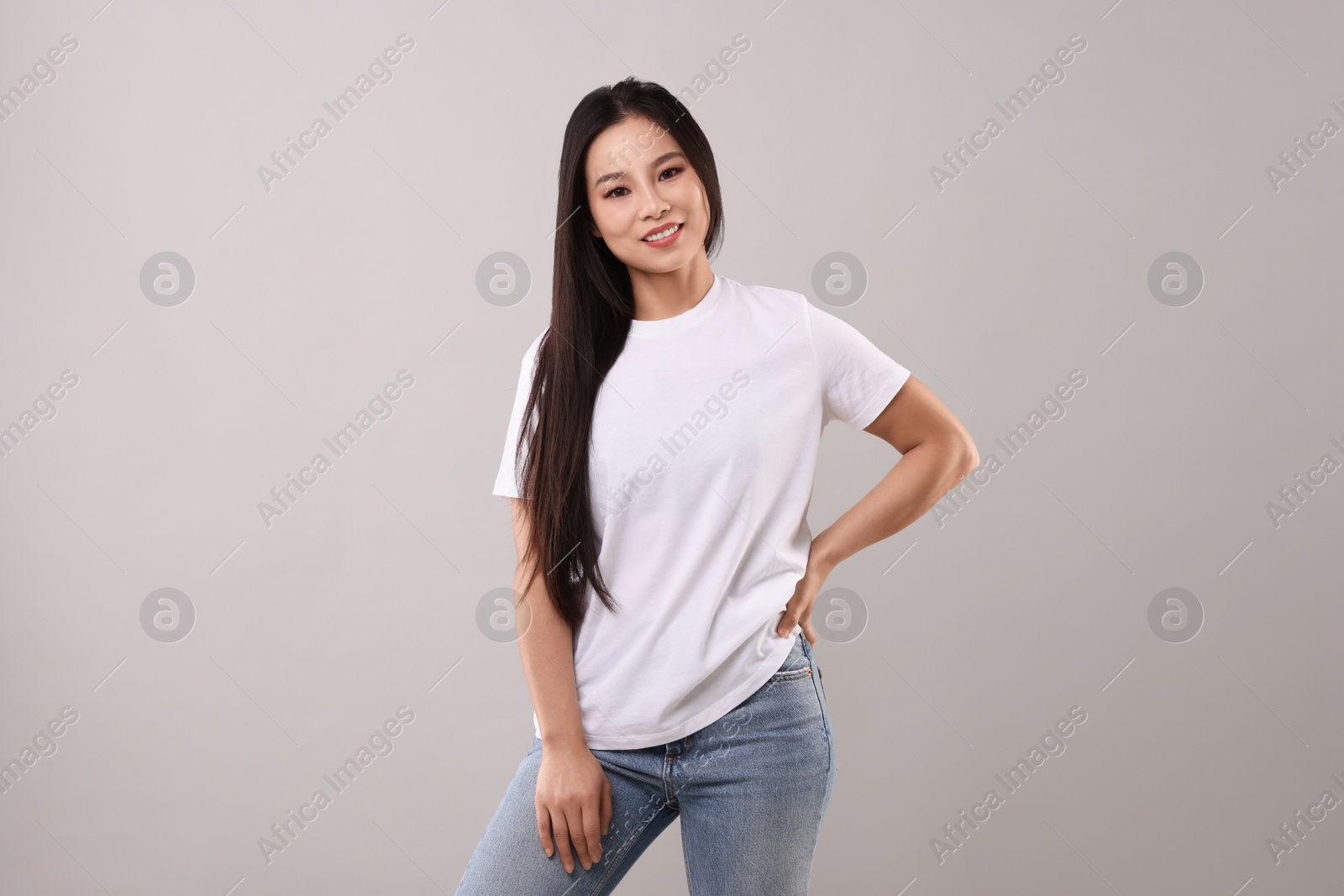 Photo of Woman wearing white t-shirt on light grey background