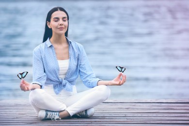 Young woman meditating near river. Space for text