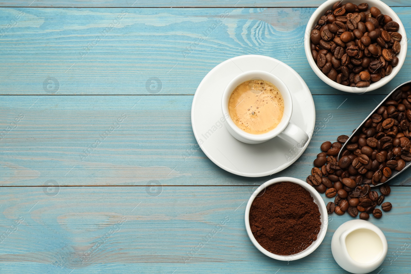 Photo of Flat lay composition with coffee grounds and roasted beans on light blue wooden table, space for text