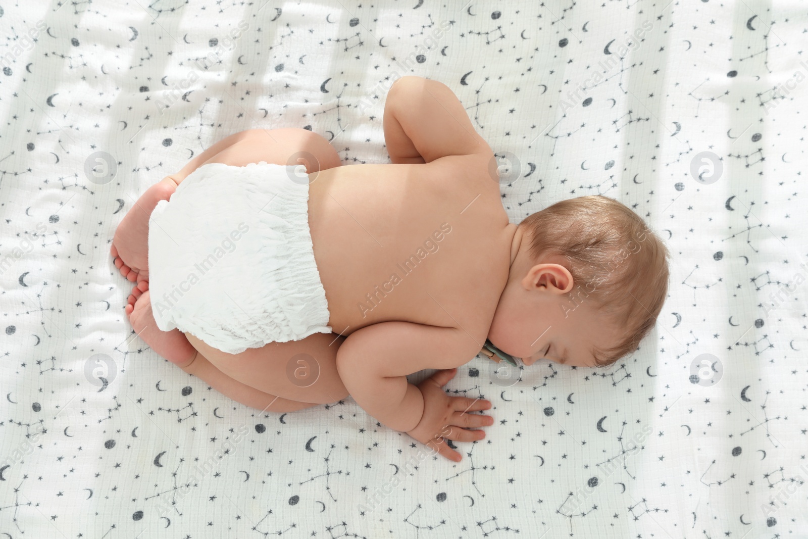 Photo of Cute little baby sleeping on soft bed, top view