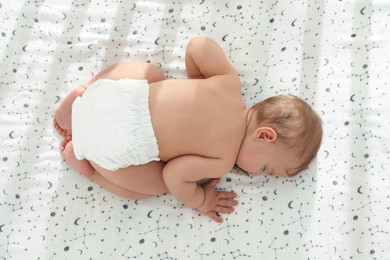 Photo of Cute little baby sleeping on soft bed, top view
