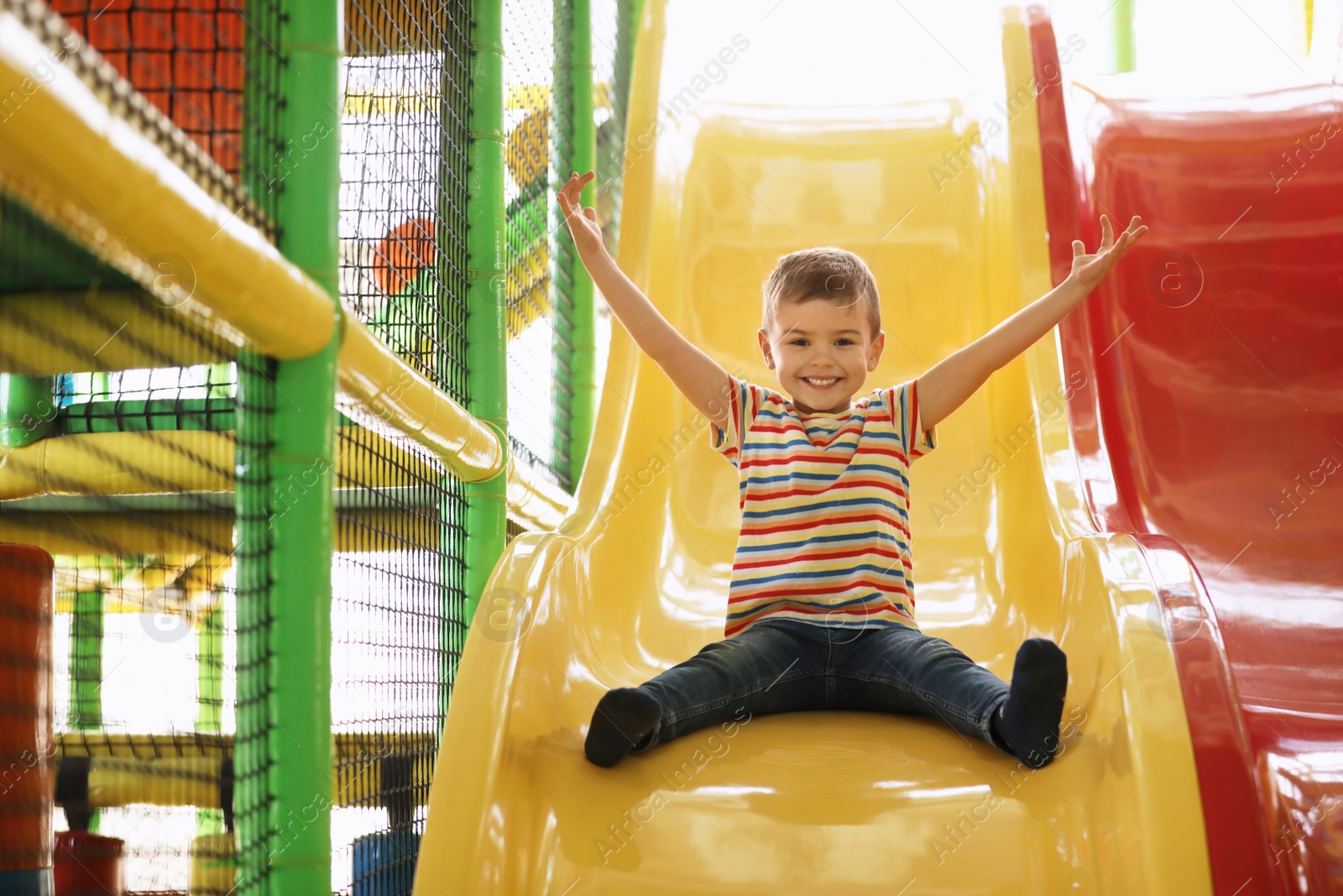 Photo of Cute little child playing at indoor amusement park