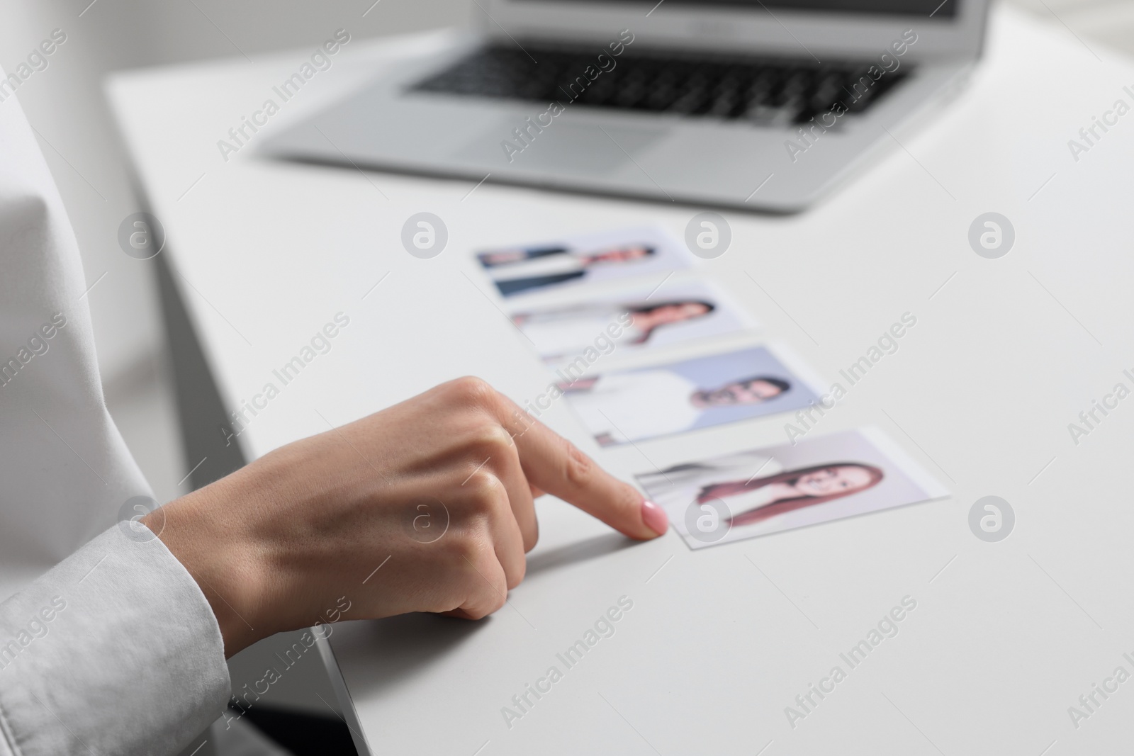 Photo of Human resources manager choosing employee among different applicants at table, closeup