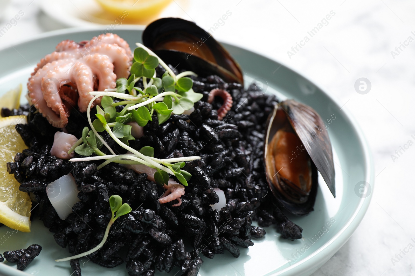 Photo of Delicious black risotto with seafood on table, closeup