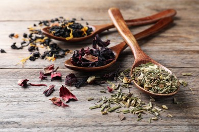 Photo of Composition with different teas and spoons on wooden table