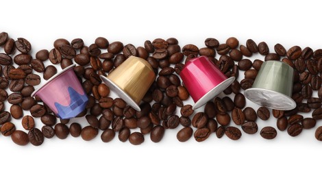 Photo of Many coffee capsules and beans on white background, top view