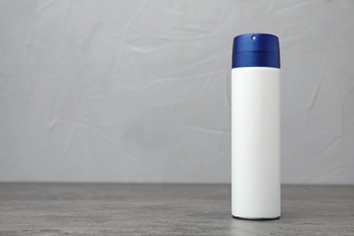 Photo of Deodorant on gray table against gray background. Skin care
