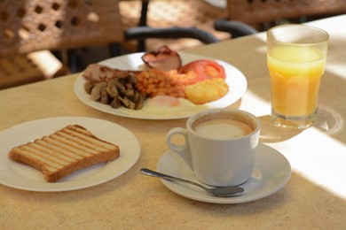 Delicious breakfast with fried meat and vegetables served on beige table