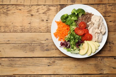 Photo of Balanced diet and healthy foods. Plate with different delicious products on wooden table, top view. Space for text